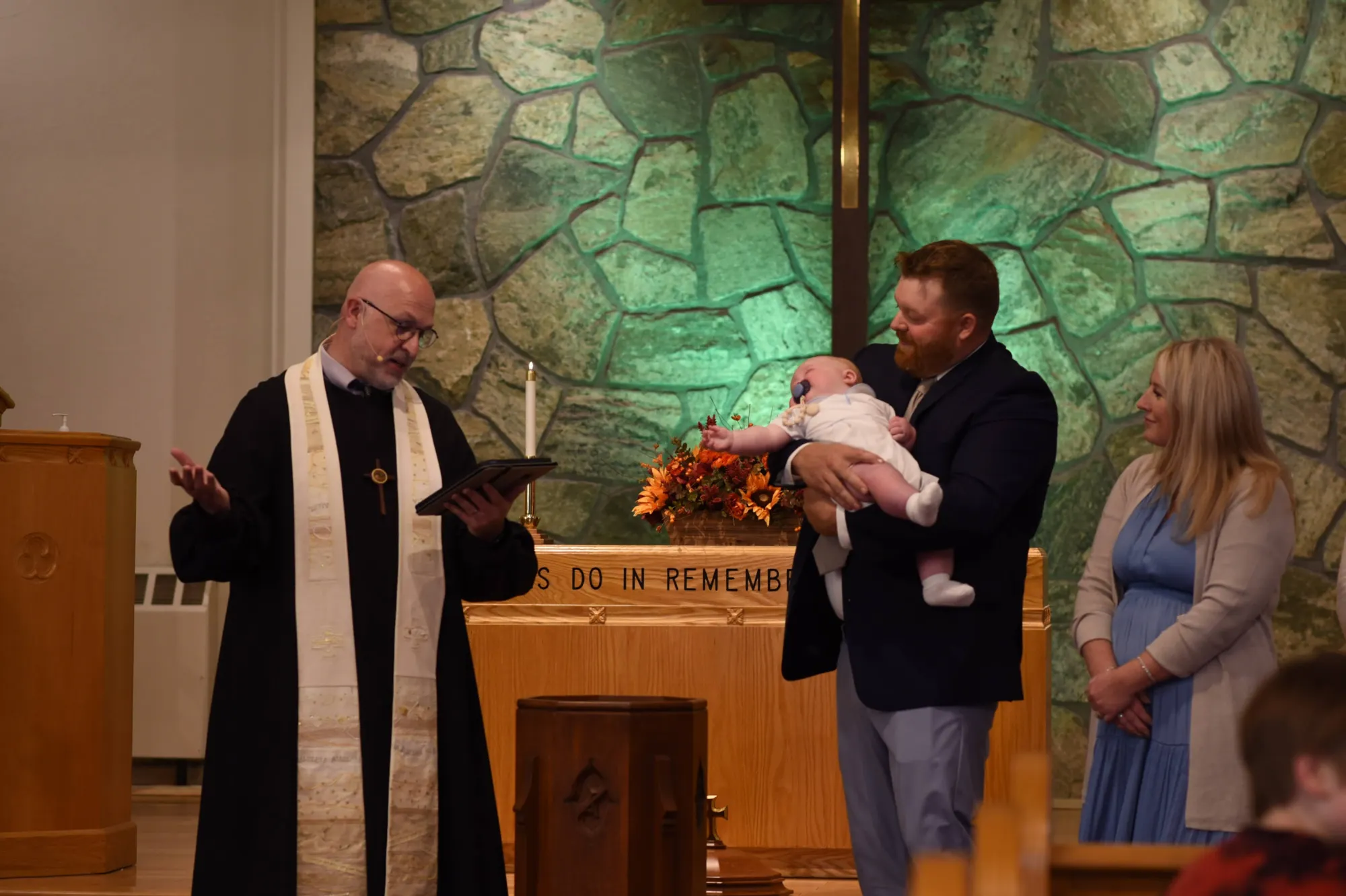 A family standing at the front of the sanctuary during a baptism ceremony