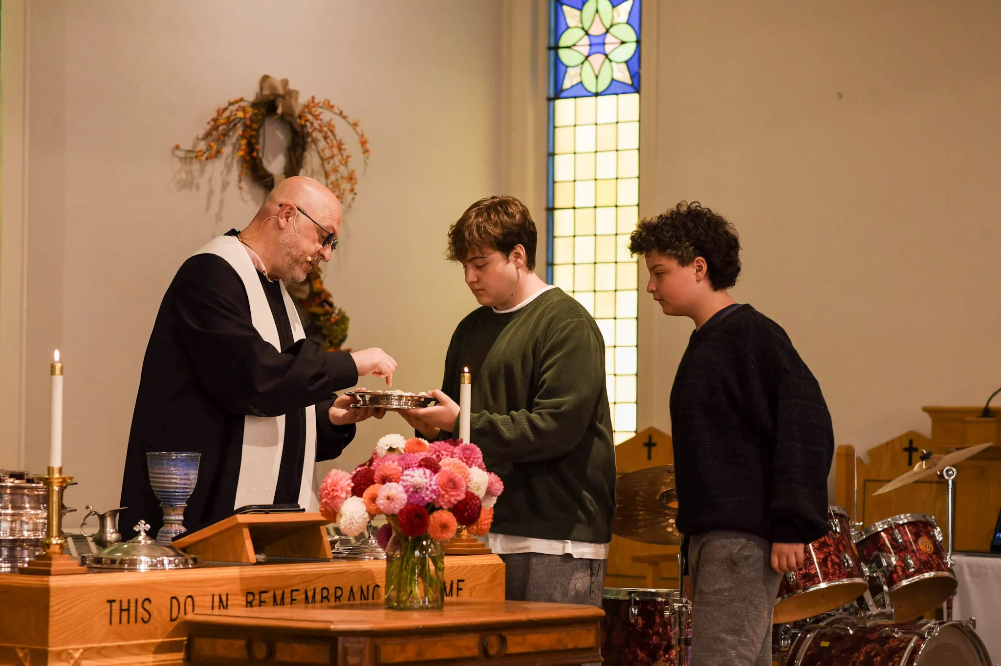 Rev. O'Brien and teens preparing to serve communion